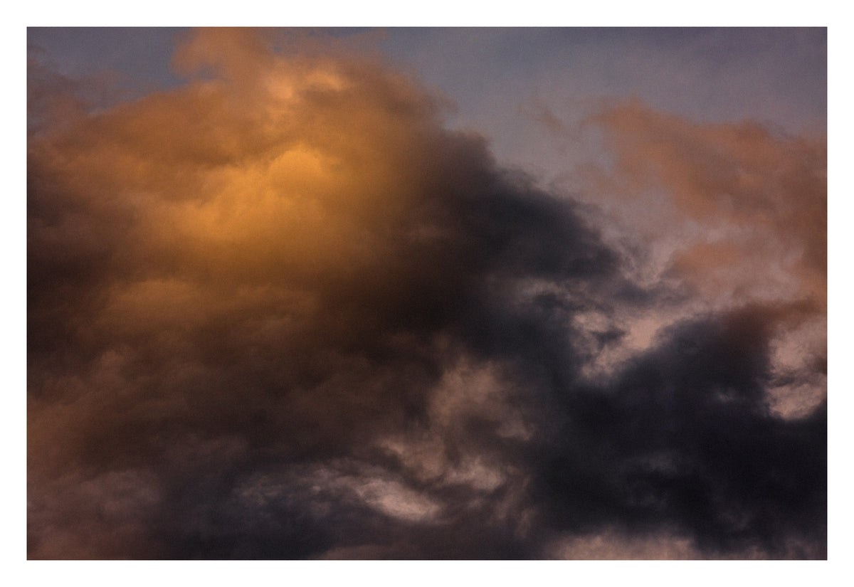 A heavy Alberta sky, with light finding one point in the darkness. Shown with the white signing border.