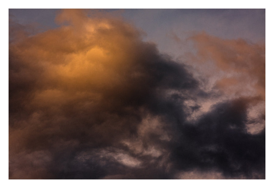 A heavy Alberta sky, with light finding one point in the darkness. Shown with the white signing border.