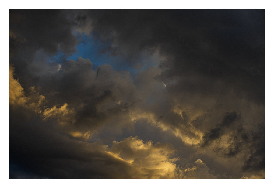 Layered Alberta cloud formations, lit from within. Shown with the white signing border.