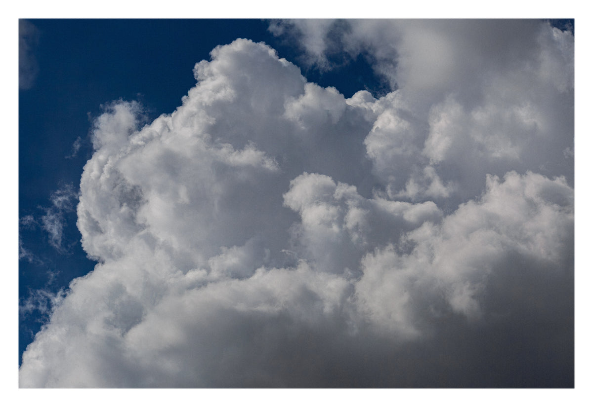 Enormous cloud formations, gentle and purposeful. Shown with the white signing border.