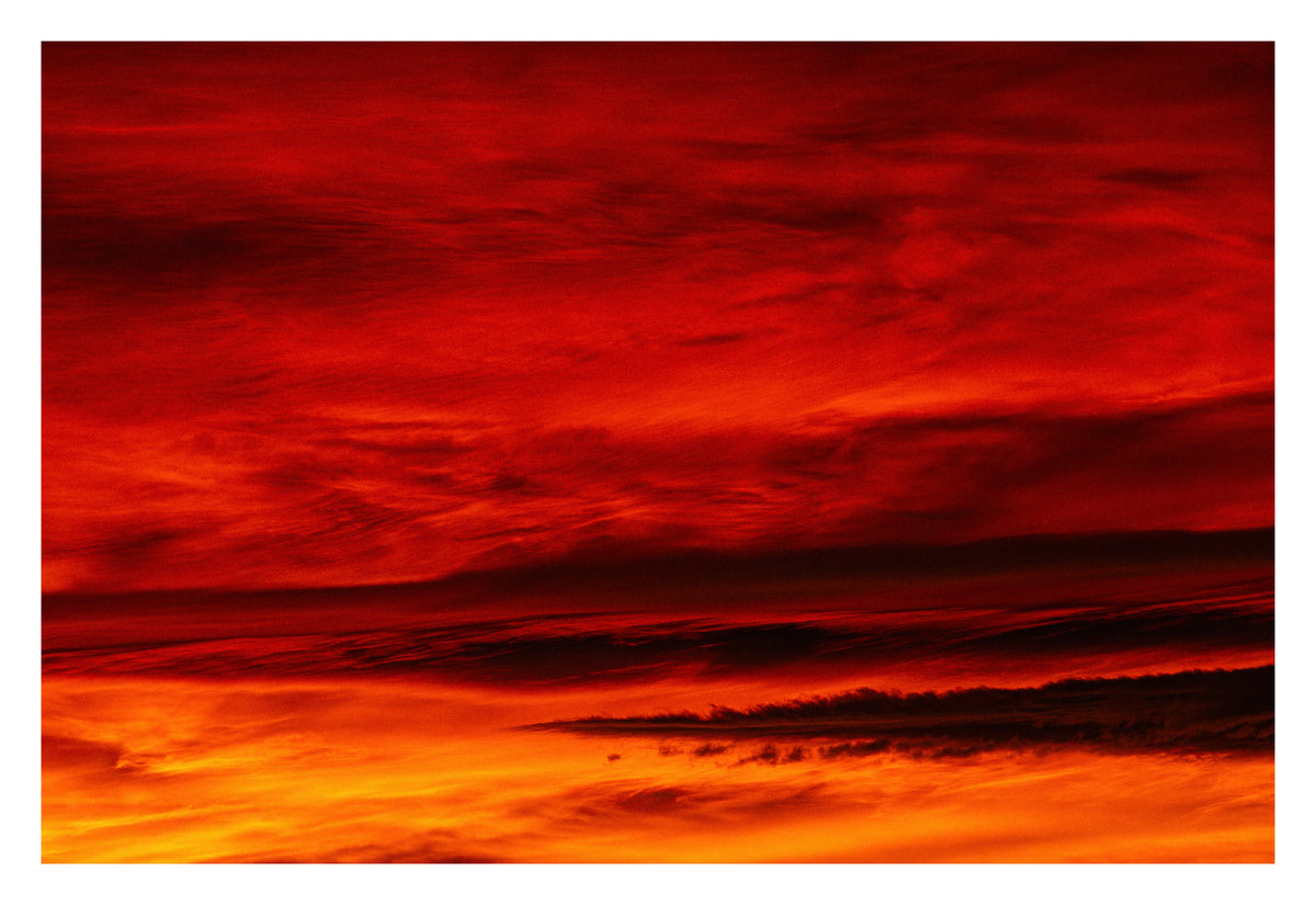 Mountains and coastlines formed entirely from cloud and light. Shown with the white signing border.