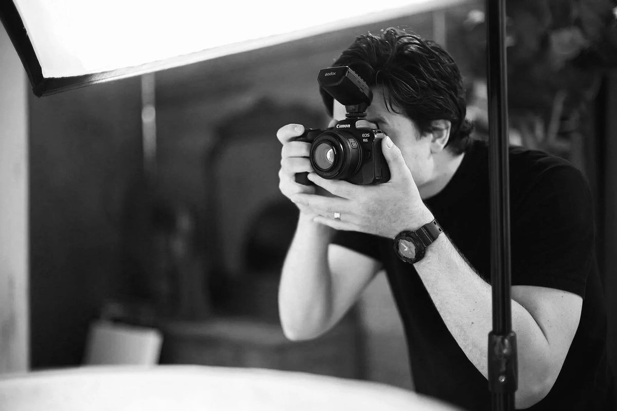 Behind the scenes in Phil's studio: the photographer at the camera beside a softbox
