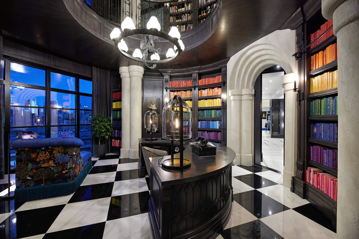 A library with stone arches, coloured books and a black and white floor